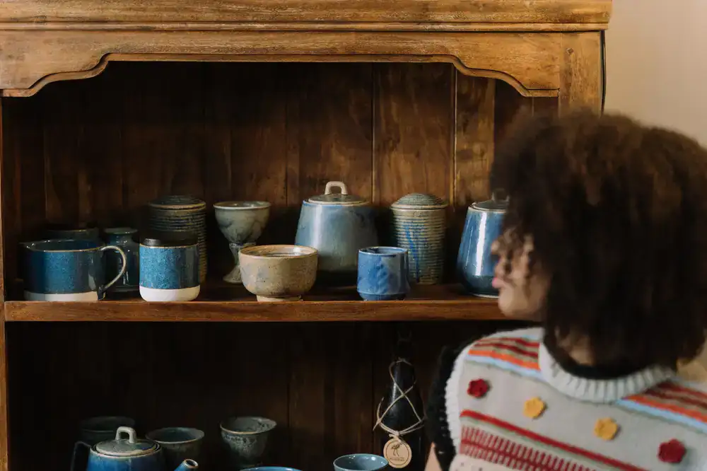 Finished glazed ceramic mugs on a wooden shelf