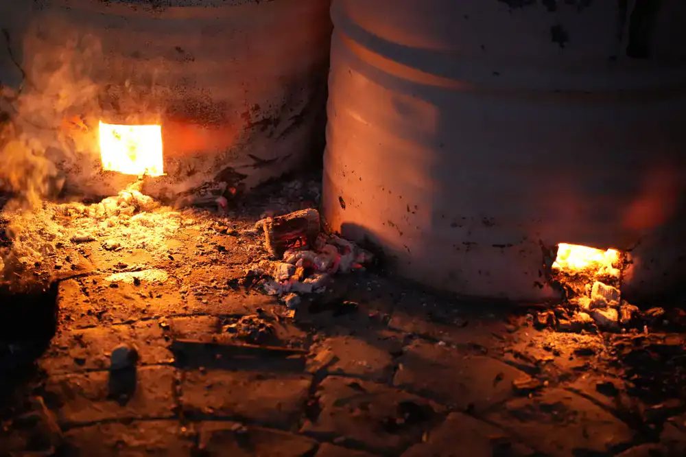 Glowing electric kiln in a dark pottery studio