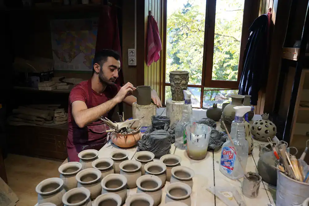 Students working at pottery wheels in the studio