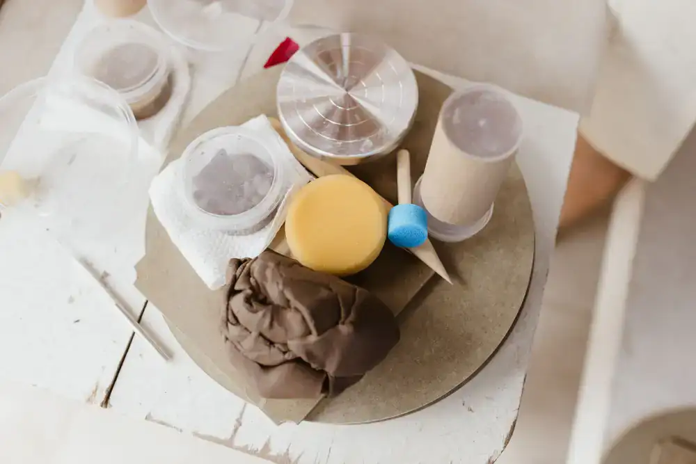 Ceramic carving tools and a sponge on a wooden table